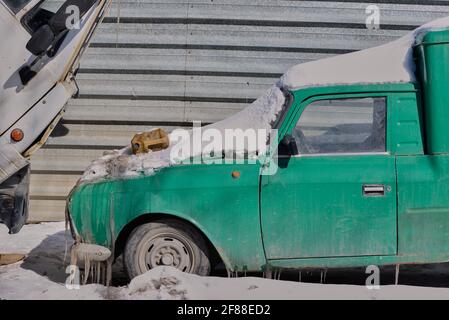 la voiture verte se trouve sous la neige en hiver Banque D'Images