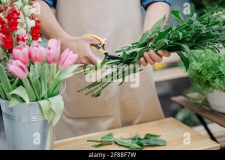 Homme entrepreneur en tablier travaillant à la fabrication de fleuriste propre bouquet seul Banque D'Images