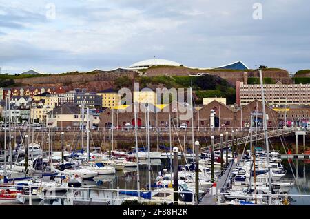 Jersey, Royaume-Uni - 09 juin 2011 : navires dans le port de plaisance de St. Helier sur l'île Channel avec musée maritime et centre de loisirs fort Regent sur la colline Banque D'Images