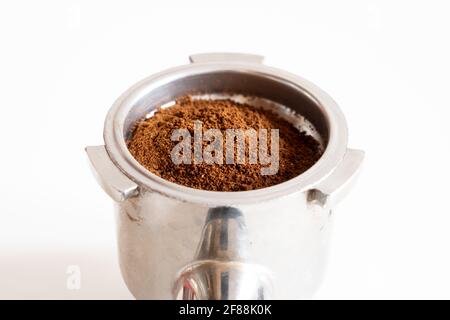 Porte-filtre avec café moulu à l'intérieur sur fond blanc en studio. Isolé. Banque D'Images