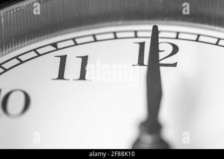 Horloge main pointant douze heures sur blanc horloge face de Réveil classique à deux cloches Banque D'Images