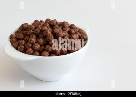 céréales au chocolat dans un bol isolé sur fond blanc, boules de chocolat, petit déjeuner sain Banque D'Images