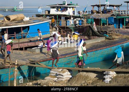 MANDALAY, MYANMAR - 21 DÉCEMBRE 2016 : déchargement d'une barge dans le port fluvial Banque D'Images