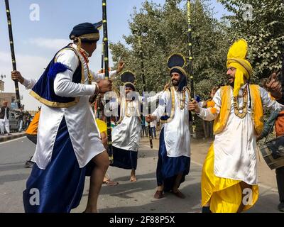 BIKANER, RAJASTHAN, INDE - JANVIER 2019 : Groupe d'artistes sikhs exécutant Punjabi Bhangra danse en robe traditionnelle jaune et bleu coloré. Banque D'Images