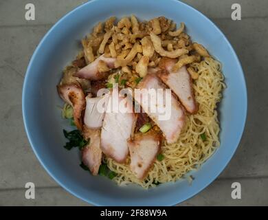 Croque d'œufs avec tranches de porc rôti rouge et Wonton, porc croustillant avec craquelure croustillante dans un bol bleu. Cuisine chinoise cantonaise, vue de dessus, sélection Banque D'Images