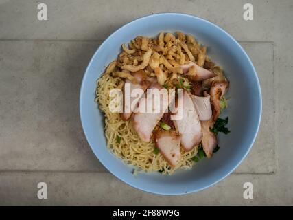 Croque d'œufs avec tranches de porc rôti rouge et Wonton, porc croustillant avec craquelure croustillante dans un bol bleu. Cuisine chinoise cantonaise, vue sur le dessus, espace copie, Sél Banque D'Images