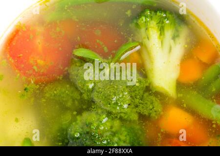 Bol de soupe minestrone avec pesto. Concentrez-vous sur le brocoli. Macro. La photo peut être utilisée comme arrière-plan entier. Banque D'Images