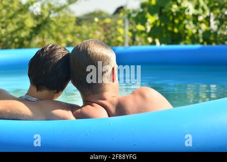 Portrait d'un jeune couple qui se détend dans la piscine Banque D'Images