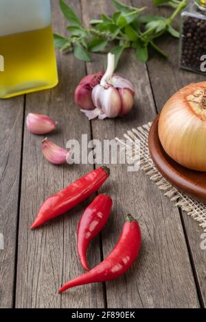 Poivrons rouges et autres assaisonnements sur table en bois. Banque D'Images