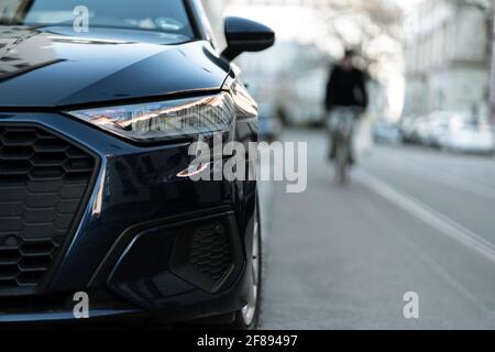 MUNICH, ALLEMAGNE - 10 avril 2021 : vue de face d'une voiture allemande dans la rue de Munich. Les cyclistes peuvent être vus en arrière-plan. Concept de mobilité avec Banque D'Images