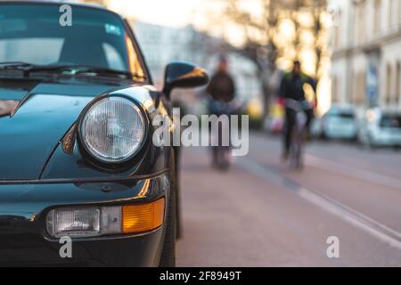 MUNICH, ALLEMAGNE - 10 avril 2021 : vue de face d'une voiture allemande dans la rue de Munich. Les cyclistes peuvent être vus en arrière-plan. Concept de mobilité avec Banque D'Images