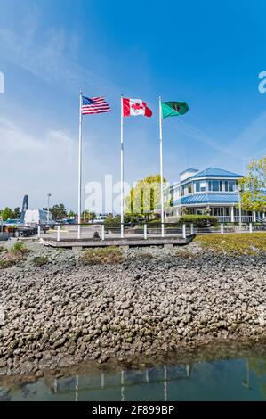 Trois drapeaux volent à la marina du port d'Anacortes à Anacortes, Washington. Banque D'Images