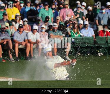 Augusta, États-Unis. 11 avril 2021. Les clients regardent Hideki Matsuyama qui sort du bunker pour atteindre le 18e vert sur le chemin d'une bogie pour gagner les Masters d'un seul coup le dimanche 11 avril 2021, au club de golf national d'août à Augusta, Géorgie. (Photo de Curtis Compton/Atlanta Journal-Constitution/TNS/Sipa USA) crédit: SIPA USA/Alay Live News Banque D'Images