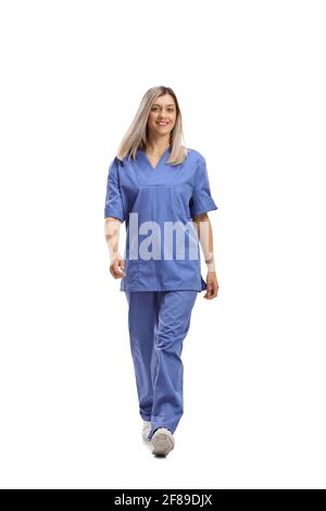 Portrait complet d'une travailleuse de la santé dans un uniforme bleu qui se dirige vers la caméra, isolé sur fond blanc Banque D'Images