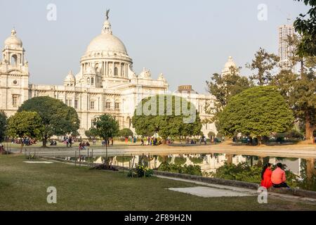 Kolkata, Bengale-Occidental, Inde - janvier 2018: Personnes assises dans les jardins de l'ancienne architecture coloniale du Victoria Memorial dans la ville de Cal Banque D'Images