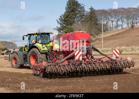 Vue arrière d'un semoir Horsch Pronto Tiré par un tracteur Claas Axion 940 sur un Soleil Printemps après-midi Banque D'Images