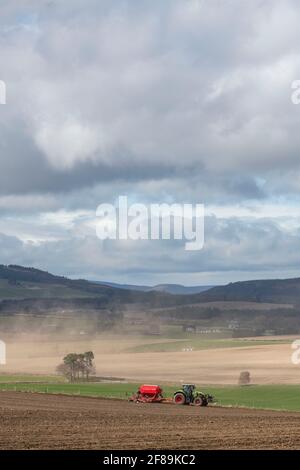 Le vent érodant le sol des terres agricoles d'Aberdeenshire avec un tracteur Et semoir semis d'orge dans le premier sol Banque D'Images