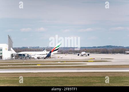 MUNICH, ALLEMAGNE - 10 avril 2021 : Emirates Airplane se trouve au terminal de l'aéroport de Munich. Les voyageurs partent et embarquèrent dans l'avion pour leurs vacances Banque D'Images