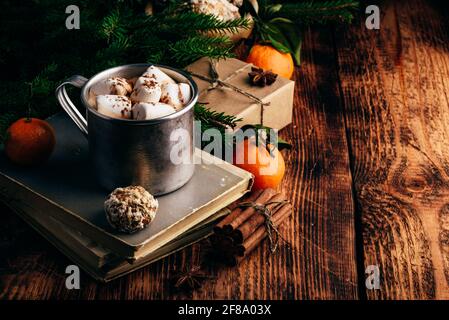 Chocolat chaud avec guimauves et pain d'épice sur de vieux livres Banque D'Images