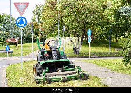 Tondeuse sur herbe dans le parc de la ville. Travaux d'été dans les villes européennes. Tondeuse professionnelle pour couper les pelouses, couper l'herbe à l'extérieur. Conservation Banque D'Images