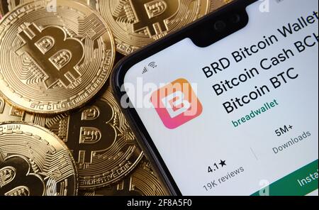 BRD Bitcoin Wallet application visible sur l'écran du smartphone placé sur la pile de pièces bitcoin supérieure. Concept. Stafford, Royaume-Uni, 12 avril 2021. Banque D'Images