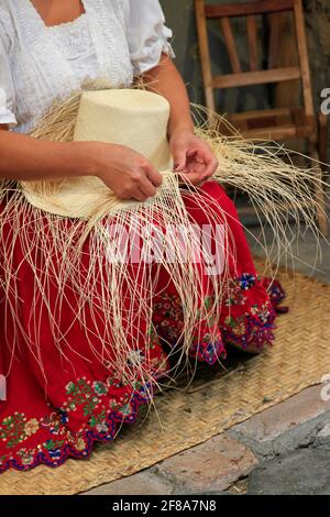 Les mains de la femme Weaving un chapeau de paille Panama à Cuenca, Equateur, Amérique du Sud Banque D'Images