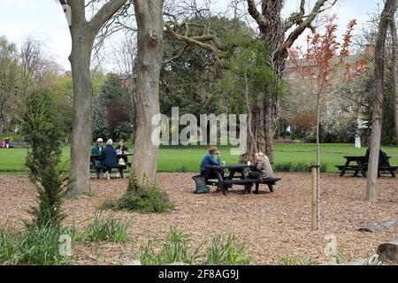 Dublin. 13 avril 2021. Les gens bavardes en plein air à Dublin, Irlande, le 12 avril 2021. L'Irlande a commencé lundi à assouplir certaines de ses restrictions COVID-19 comme prévu. Les gens sont autorisés à voyager librement dans le comté où ils vivent ou à moins de 20 kilomètres de leur maison, avec des rassemblements en plein air autorisés pour pas plus de deux ménages, l'éducation en classe pour tous les élèves du primaire et du secondaire a repris, et tous les projets de construction résidentielle ont rouvert. Credit: Xinhua/Alay Live News Banque D'Images