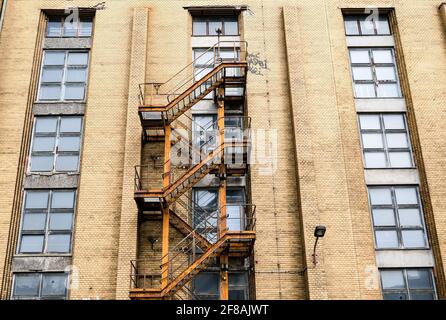 09 avril 2021, Berlin: Une vieille évacuation incendie peut être vue sur la façade d'un hall industriel dans la zone industrielle d'Oberschöneweide. Dans quelques mois, les travaux de restauration et de revitalisation du site inscrit doivent commencer d'ici 2025. Quatre nouveaux bâtiments doivent également être ajoutés. Le trimestre comprend des utilisations commerciales comme les bureaux, les restaurants et les studios et, à l'est, le campus de BaseCamp. Il comprend une auberge de jeunesse et urbaine et offre d'hébergement. La zone industrielle est un monument important de l'industrie berlinoise et est considérée comme le plus grand monument industriel contigu d'Europ Banque D'Images