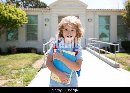 Enfant avec sacs à dos debout dans le parc près de l'école. Élèves avec des livres et des sacs à dos à l'extérieur. Enfant avec sac à dos pour aller à l'école. Éducation des enfants Banque D'Images