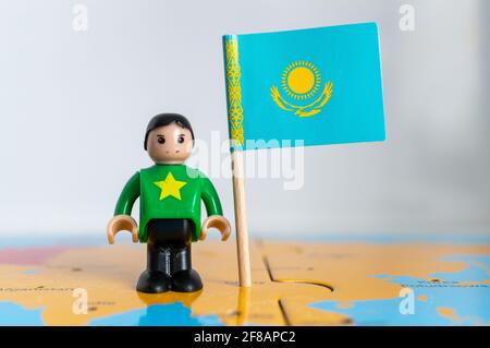 POZNAN, POLOGNE - 06 avril 2021 : figurine jouet joutive située à côté d'un drapeau national du Kazakhstan. Banque D'Images