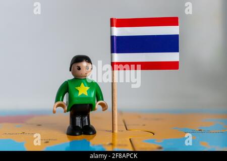 POZNAN, POLOGNE - 06 avril 2021 : figurine jouet joutive située à côté d'un drapeau national thaïlandais. Banque D'Images