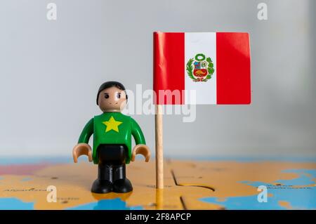 POZNAN, POLOGNE - 06 avril 2021 : figurine jouet joutive située à côté d'un drapeau national péruvien. Banque D'Images