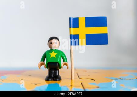 POZNAN, POLOGNE - 06 avril 2021 : figurine jouet joutive située à côté d'un drapeau national suédois. Banque D'Images
