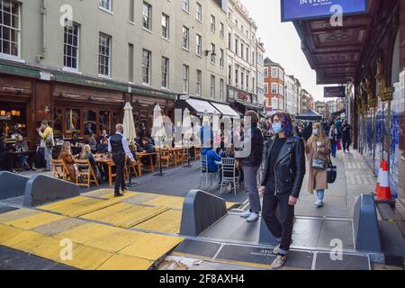 Londres, Royaume-Uni. 12 avril 2021. Bars et restaurants animés dans Old Compton Street, Soho. Les magasins, restaurants, bars et autres entreprises ont rouvert après presque quatre mois, alors que les règles de verrouillage sont assouplies en Angleterre. Banque D'Images