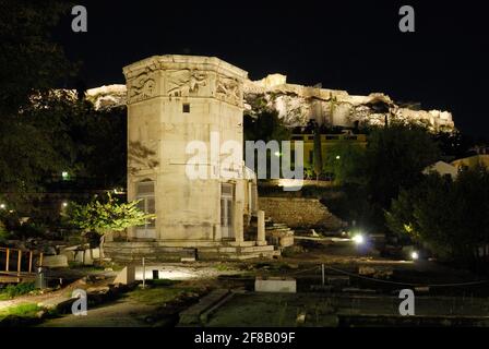 Prise de vue nocturne de la Tour illuminée des vents ou de l'Horologion d'Andronikos Kyrrhéstes avec l'Acropole derrière, tour d'horloge octogonale en marbre pentélique Banque D'Images