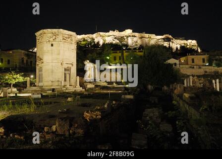 Prise de vue nocturne de la Tour illuminée des vents ou de l'Horologion d'Andronikos Kyrrhéstes avec l'Acropole derrière, tour d'horloge octogonale en marbre pentélique Banque D'Images