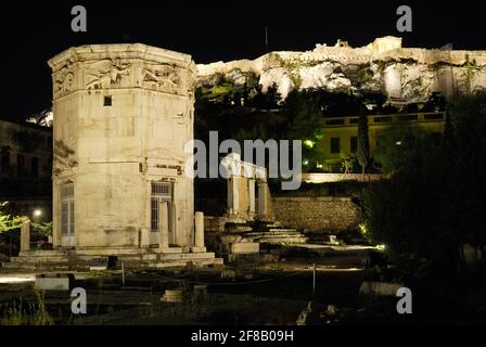 Prise de vue nocturne de la Tour illuminée des vents ou de l'Horologion d'Andronikos Kyrrhéstes avec l'Acropole derrière, tour d'horloge octogonale en marbre pentélique Banque D'Images