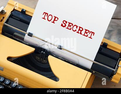 Top Secret sur une feuille blanche de papier dans l'ancien machine à écrire jaune Banque D'Images