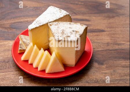 Collection de fromages, tomme de Savoie de Savoie dans les Alpes françaises, fromage de lait de vache doux avec intérieur beige et croûte épaisse gris brunâtre Banque D'Images