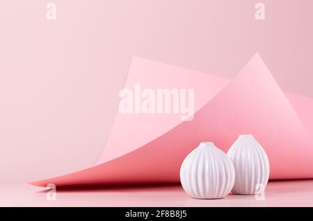 Décoration maison avec vases en céramique blanche sur fond géométrique rose pastel avec papier incurvé, coin de pic. Intérieur moderne, élégant et minimaliste. Banque D'Images