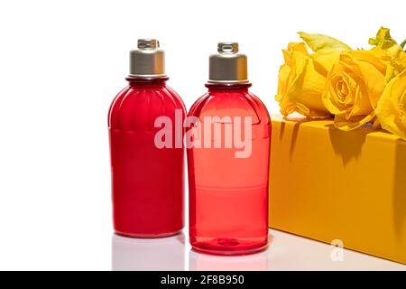 Flacons rouges pour gel douche et crème sur fond blanc. Bocaux en plastique légers. Sur fond blanc. Ombres dures. Isolats. Concept de cadeau. Banque D'Images