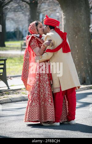 Un couple hindou en vêtements ethniques très ornés pose pour des photos avant mariage dans un parc à Queens, New York. Banque D'Images