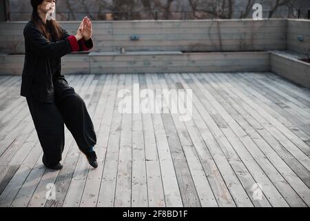 Palmiers croisés maintenus par une femme en position tai chi Banque D'Images