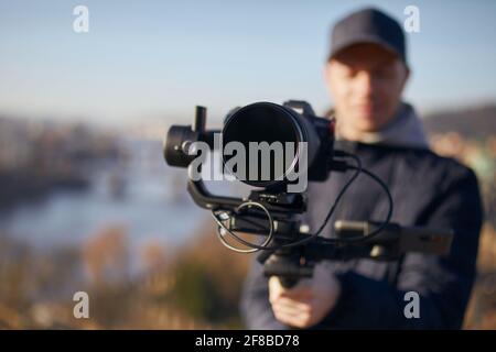Créateur de contenu pendant la prise de vue avec la nacelle. Mise au point sélective sur l'objectif de l'appareil photo. Banque D'Images
