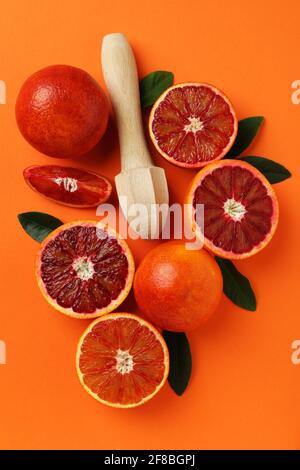 Oranges rouges, feuilles et centrifugeuse sur fond orange Banque D'Images
