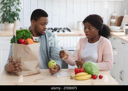 Des prix choquants. Une famille afro-américaine frustrée vérifie les factures après les courses Banque D'Images