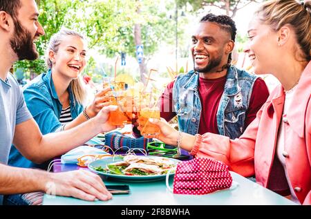 Des amis se frapune au bar-restaurant en plein air - Concept de style de vie avec les jeunes s'amusant ensemble partage boissons à l'happy hour Banque D'Images