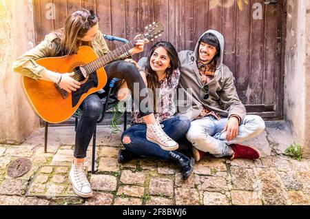 Amis jouant de la guitare à l'extérieur Banque D'Images