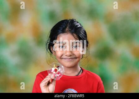 Mumbai, Maharashtra, Inde, Asie, août 05, 2006 - six ans mignonne petite fille indienne appréciant jouer bulles d'eau soufflantes Banque D'Images