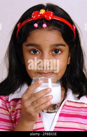 Mumbai, Maharashtra, Inde, Asie, septembre 24, 2006 - petite fille indienne mignonne tenant un verre de lait de boisson gardant le verre dans sa main concept sain Banque D'Images